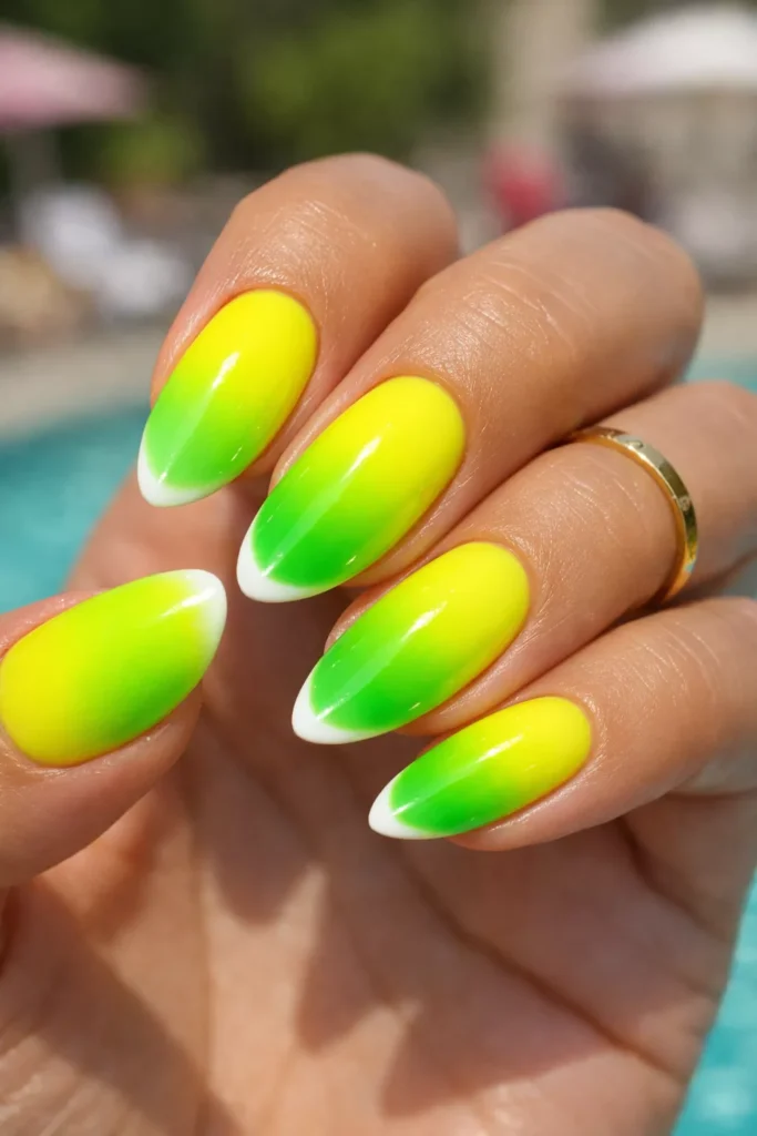 Neon yellow to lime green ombré almond-shaped summer nails.