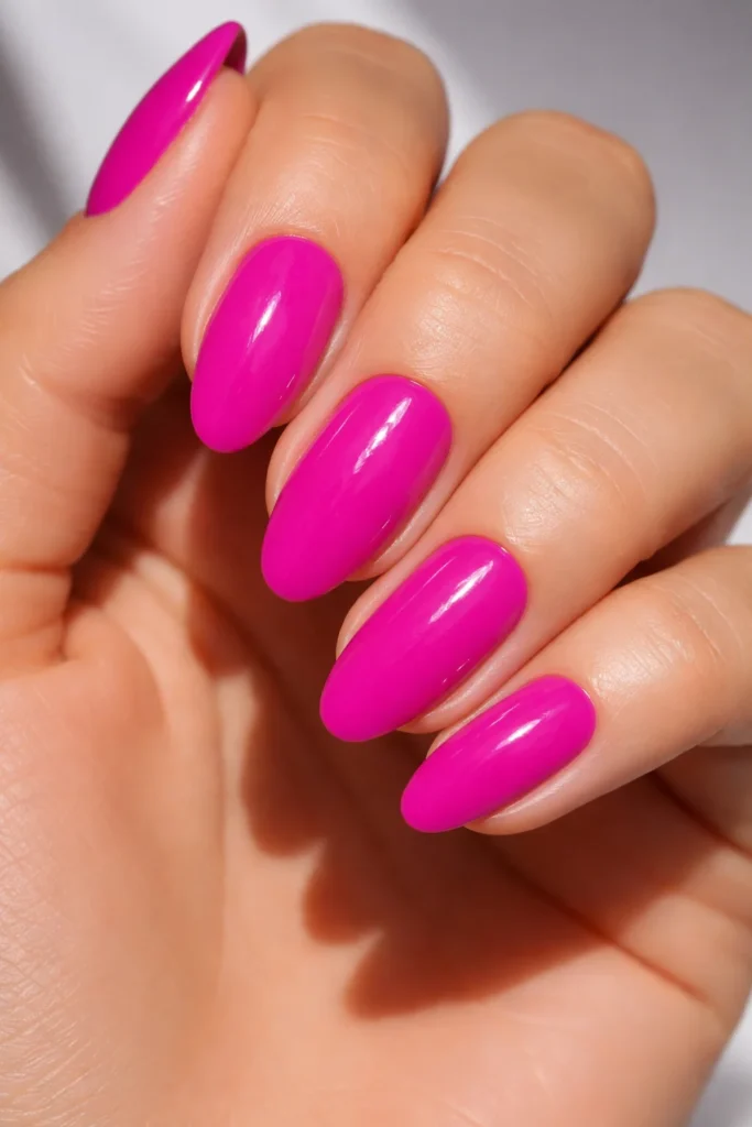 Electric magenta manicure with glossy finish, vibrant pink nail ideas.