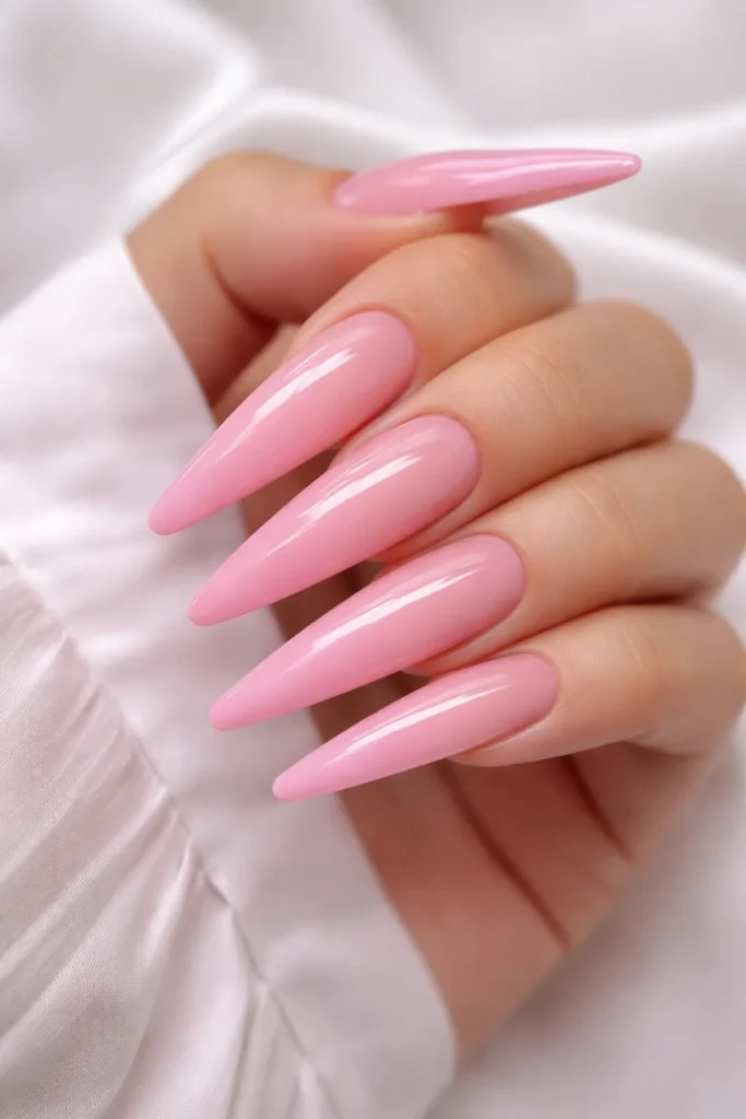 Long pink acrylic nails with dramatic shape and nail art, bold pink nail ideas.
