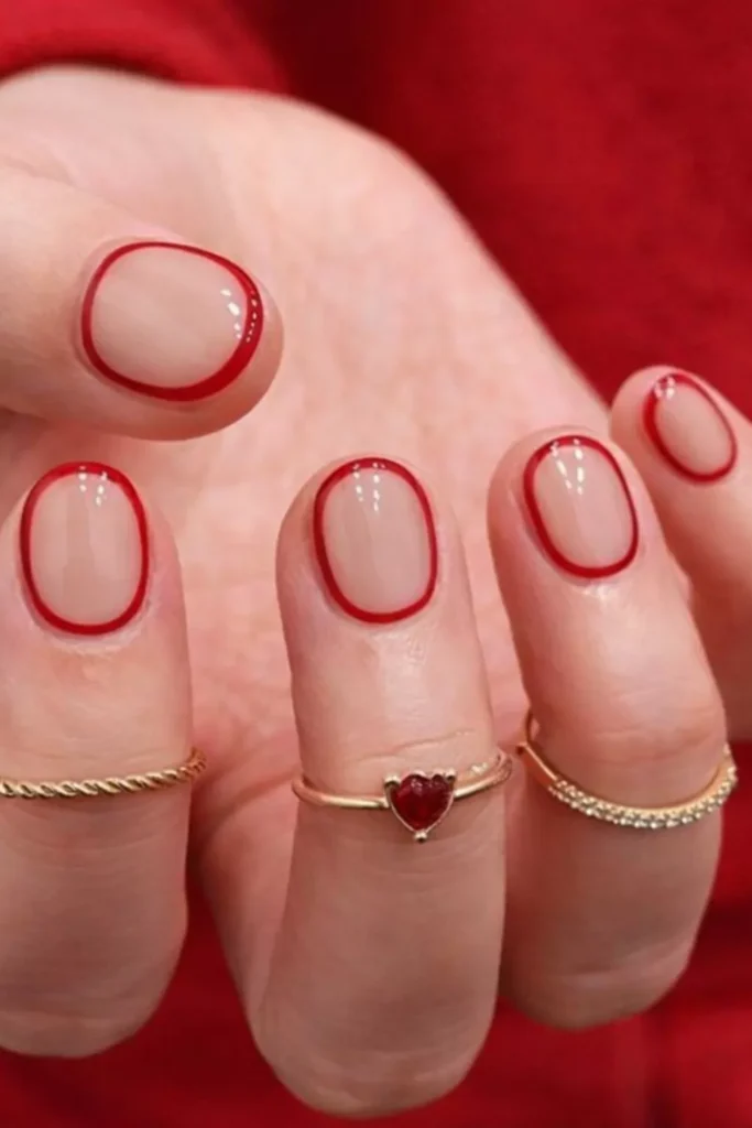 Short oval nails with a clear base and a thin, minimalist red border around the perimeter.