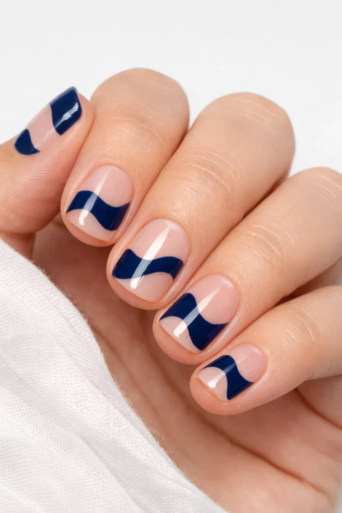 Clear and coral negative space wave nail design.