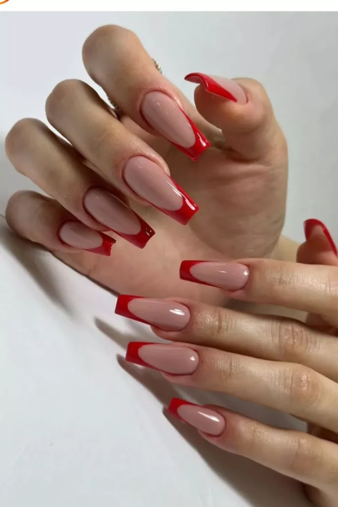Extra-long square coffin nails featuring a nude base and bold red French tips.