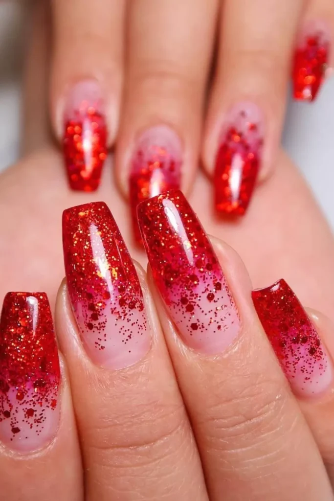 Long coffin nails featuring a nude base transitioning into a dense red glitter gradient at the tips.