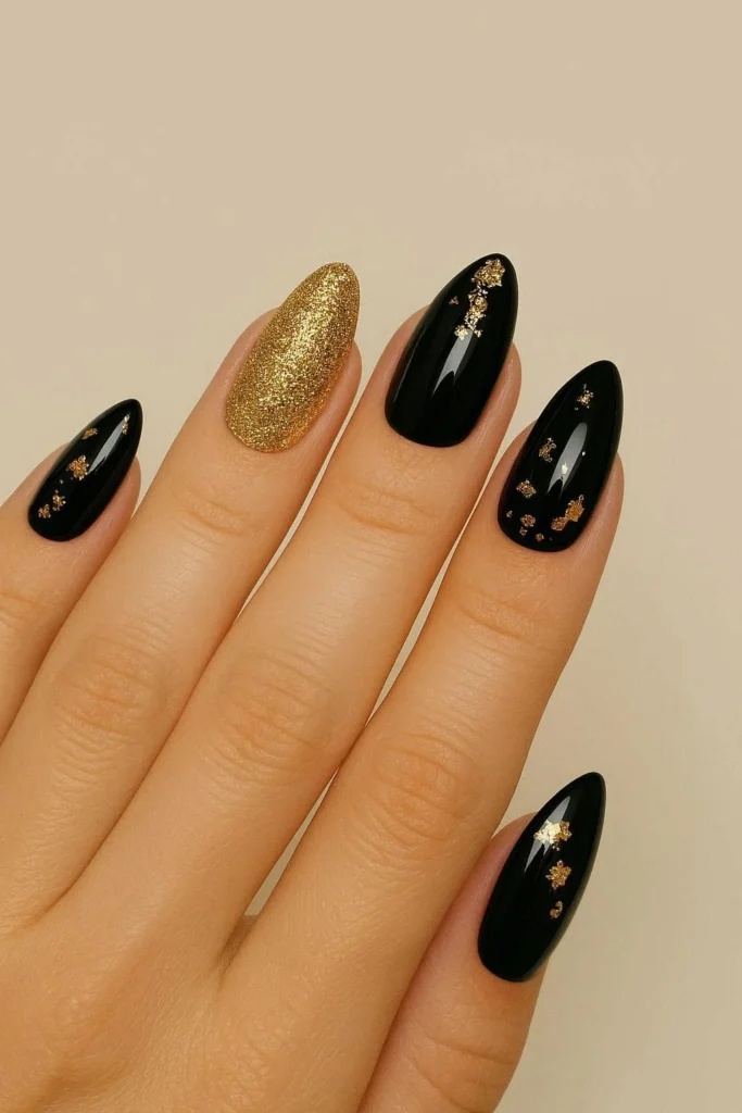 Long coffin nails with glossy black base and gold glitter accent nails for New Year's Eve