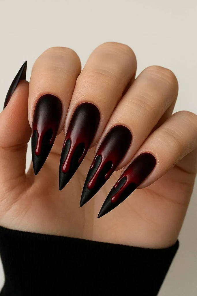 Long coffin nails with black base and dramatic red blood drip nail art for Halloween