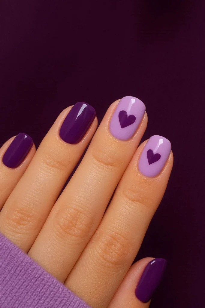 Short oval nails with lilac purple base and heart nail art for Galentine's Day