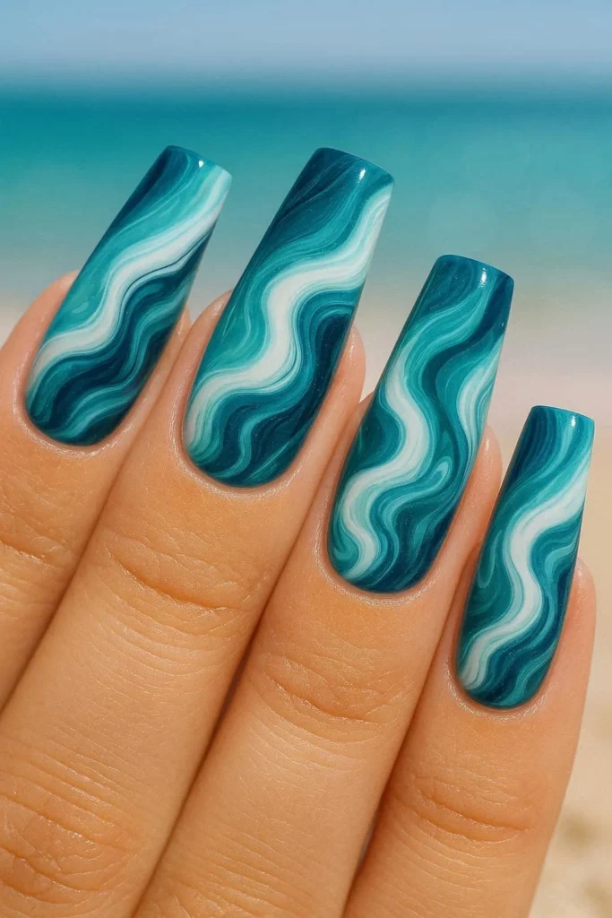 Long coffin nails with swirling teal navy and white ocean wave nail art for summer