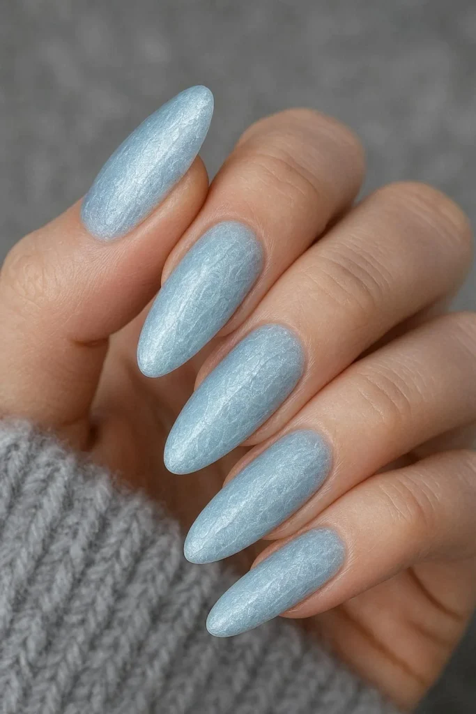 Oval coffin nails with icy pale blue shimmer polish mimicking frozen ice for winter