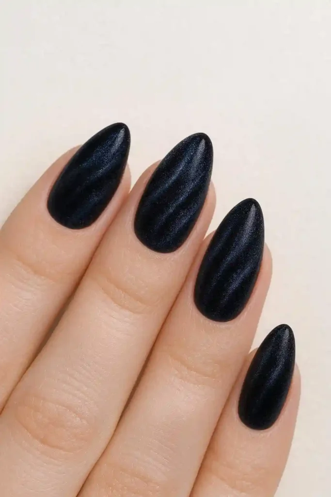 Dark velvet magnetic nails in deep emerald with ripple texture on almond nails