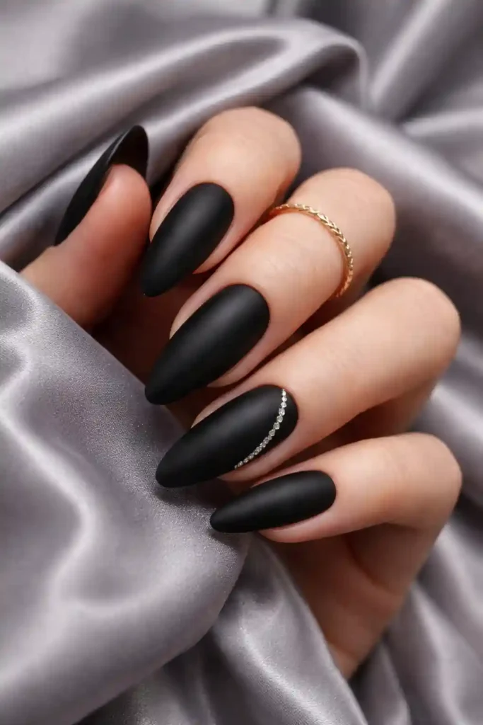 Stylish matte black manicure with elegant rhinestone line