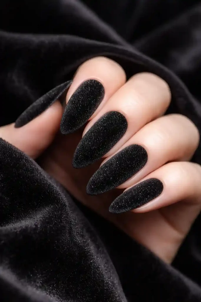 Elegant almond shaped nails with black velvet powder texture