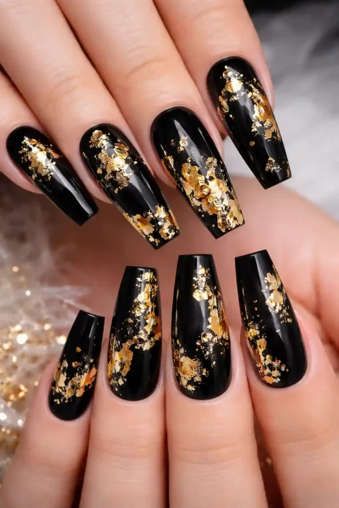 Black and gold foil nails with scattered gold leaf on coffin nails