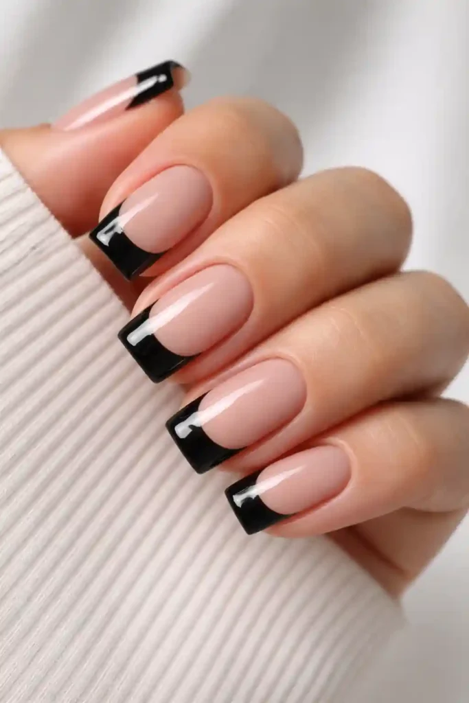Black French tip nails on short square nails with sheer nude base