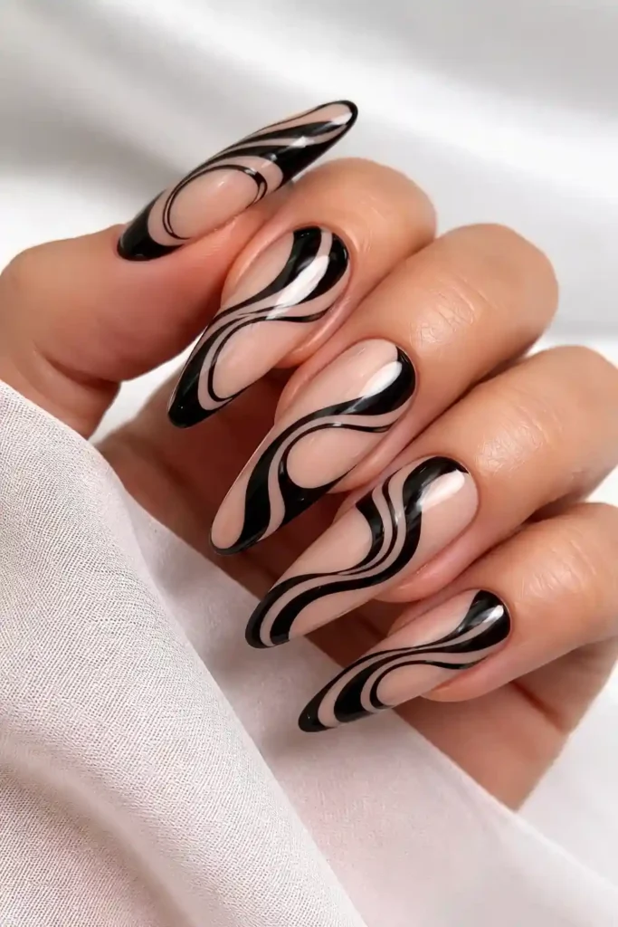 Black swirl nail art with hand-painted organic spirals on almond nails