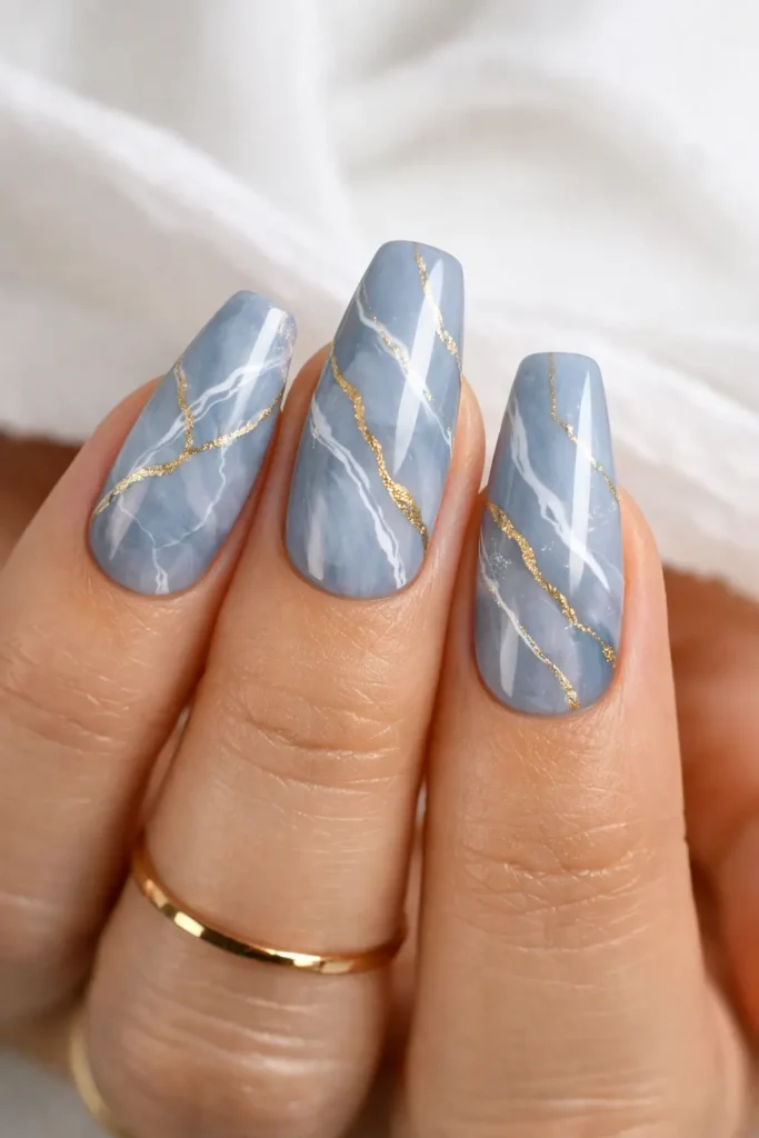 Luxury blue marble nails with white and gold veining on coffin shape