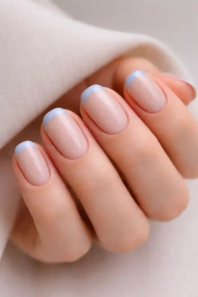 Clean blue minimalist nails with a single thin line detail on short squoval shape
