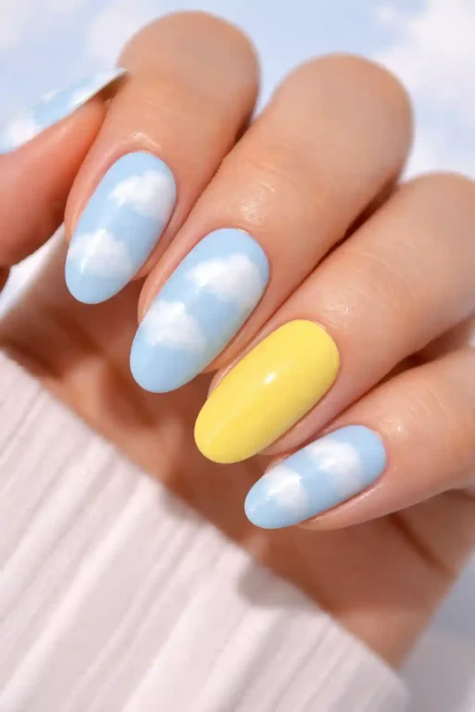 pale sky blue nails with white cloud art and lemon yellow accent nail
