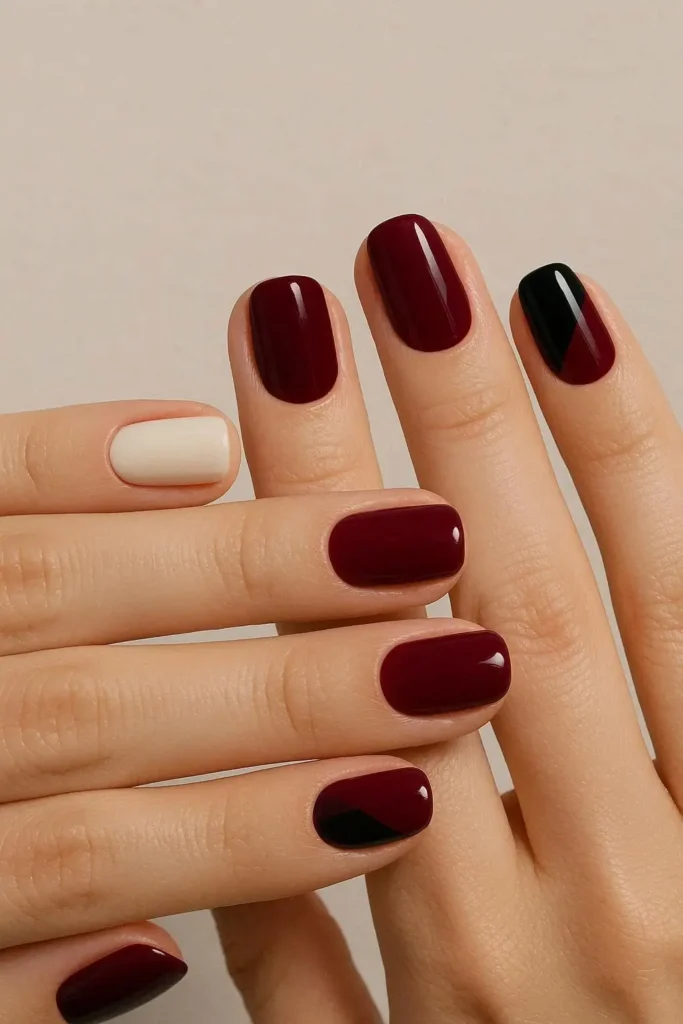 Burgundy and black ivory color block nails with diagonal split design
