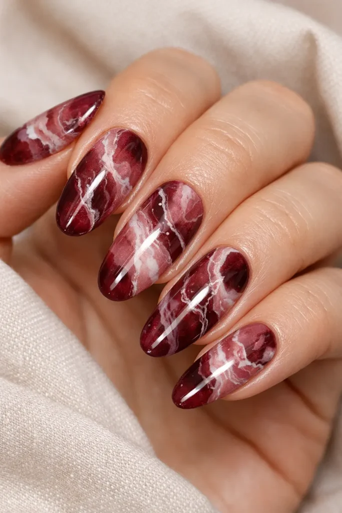 Burgundy marble nails with dusty rose and ivory veining on glossy finish