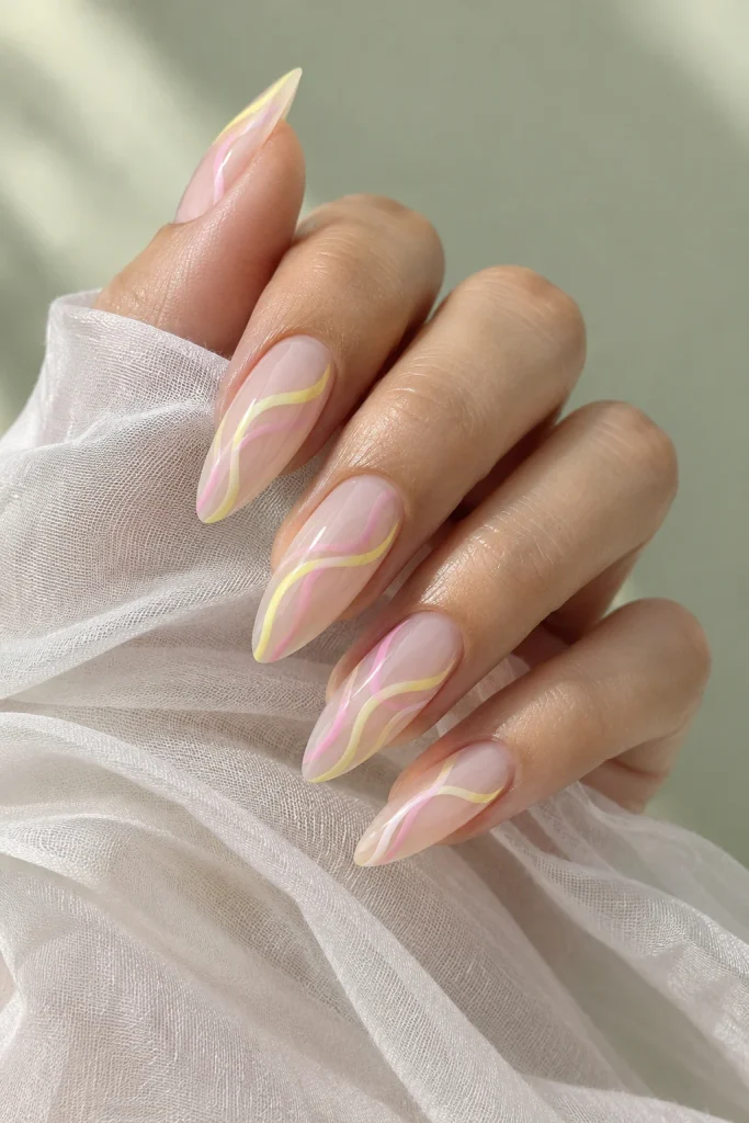 Long almond nails with wavy candy pink and lemon yellow lines over a milky base