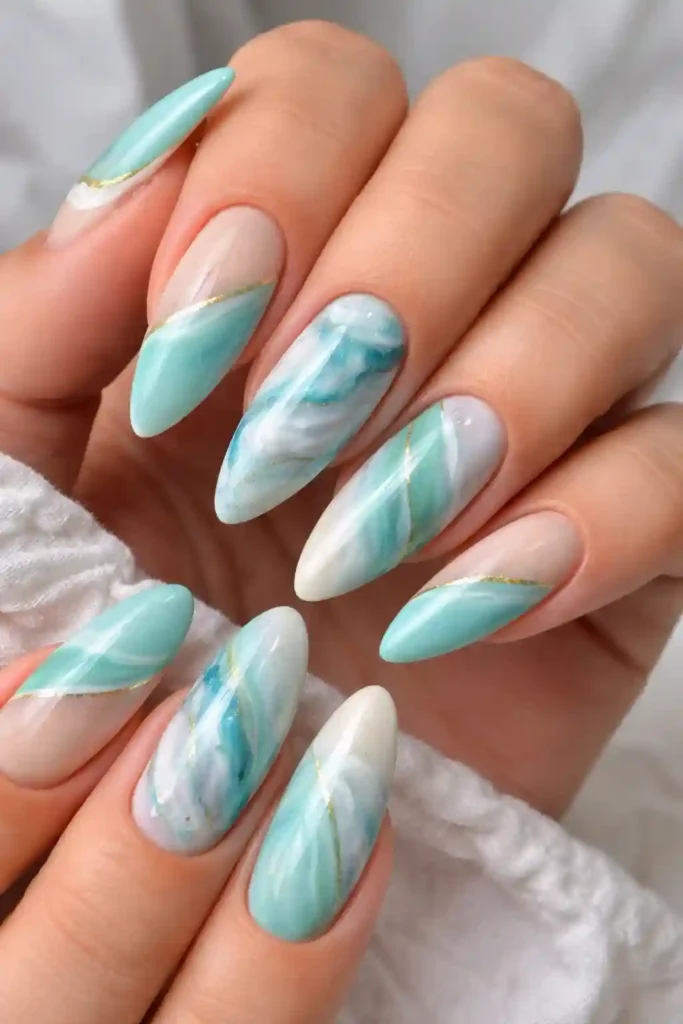 Coastal aqua and white almond nails with swirling marble pattern