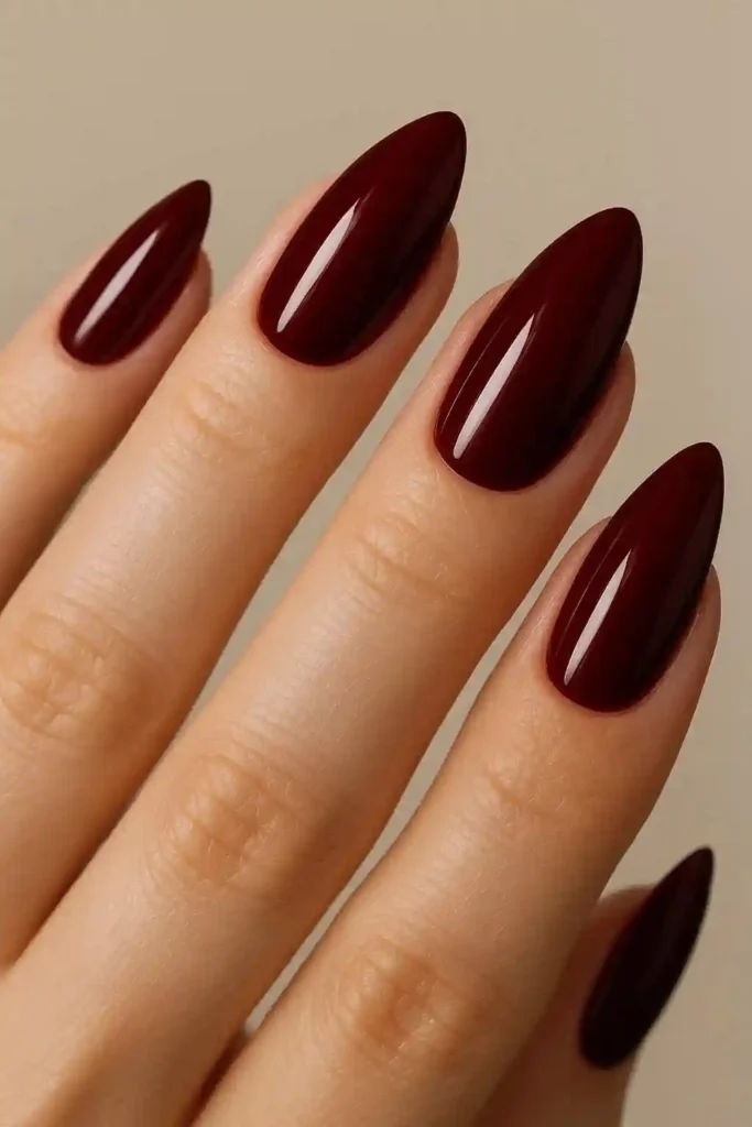 Dark cherry red almond nails with glossy jewel-tone finish