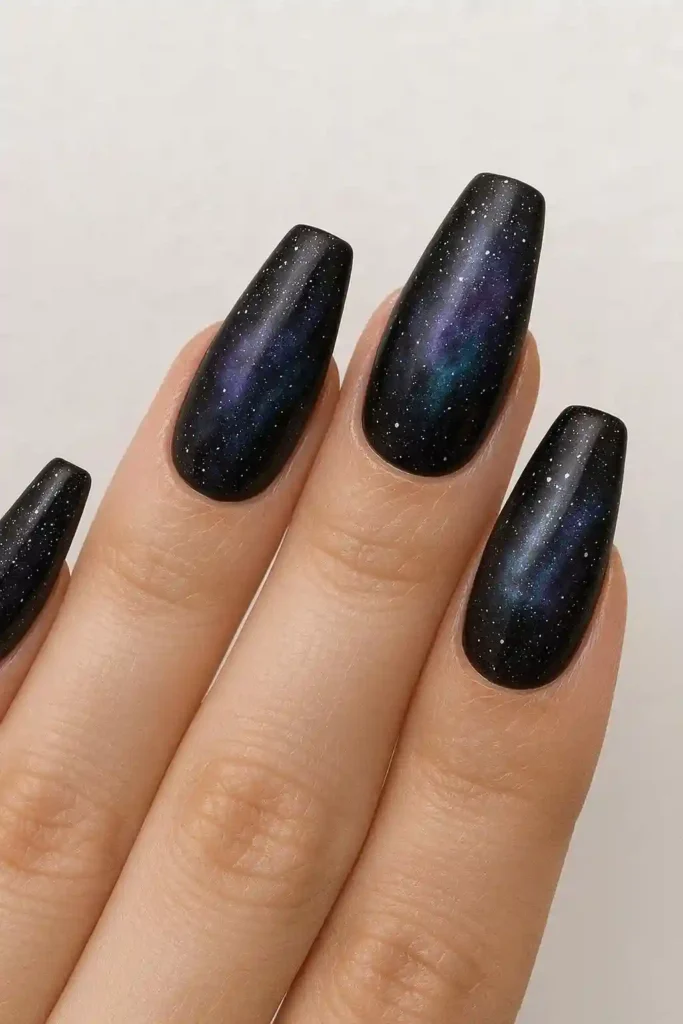 Dark galaxy nail art with deep purple navy and silver glitter on coffin nails