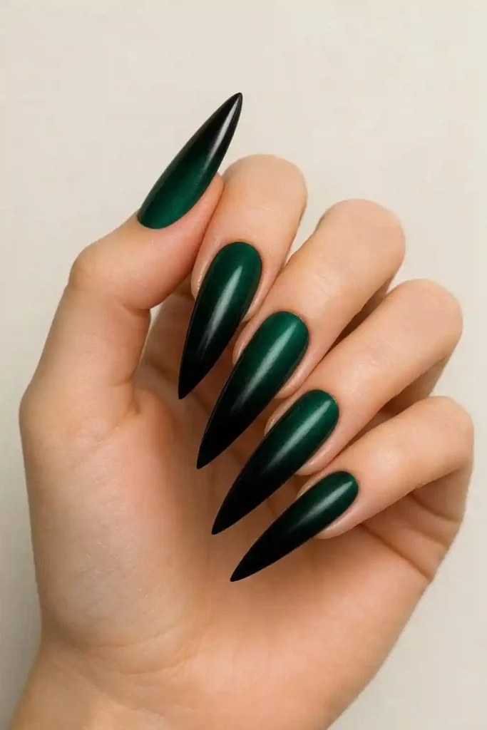 Dark gradient ombre nails fading from deep emerald to black on stiletto nails