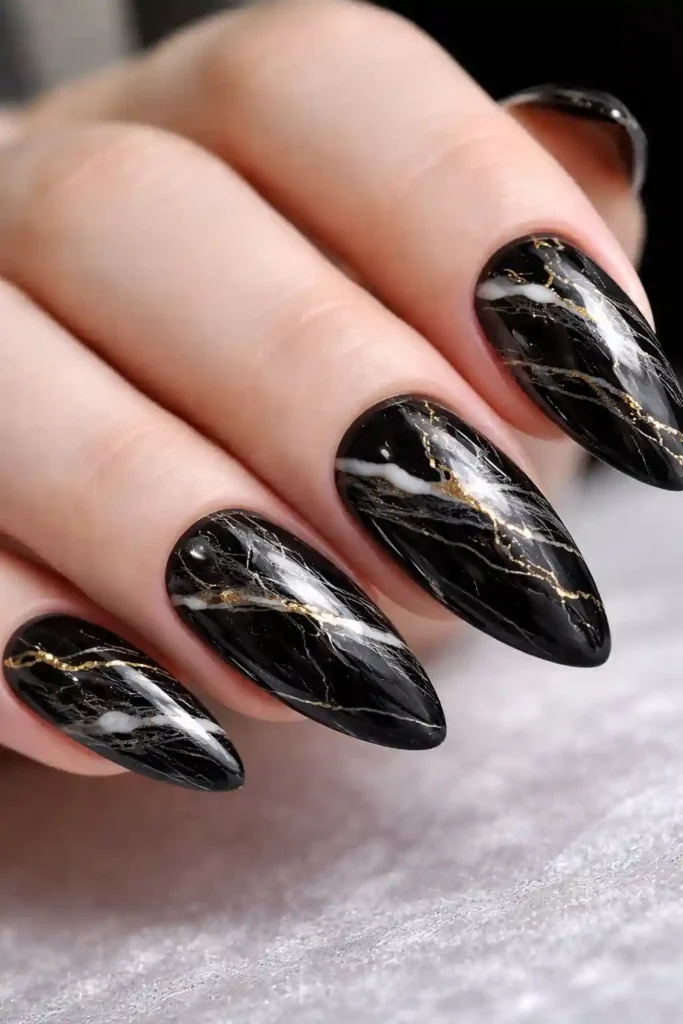 Dark marble nails with charcoal base and white gold veining on almond nails