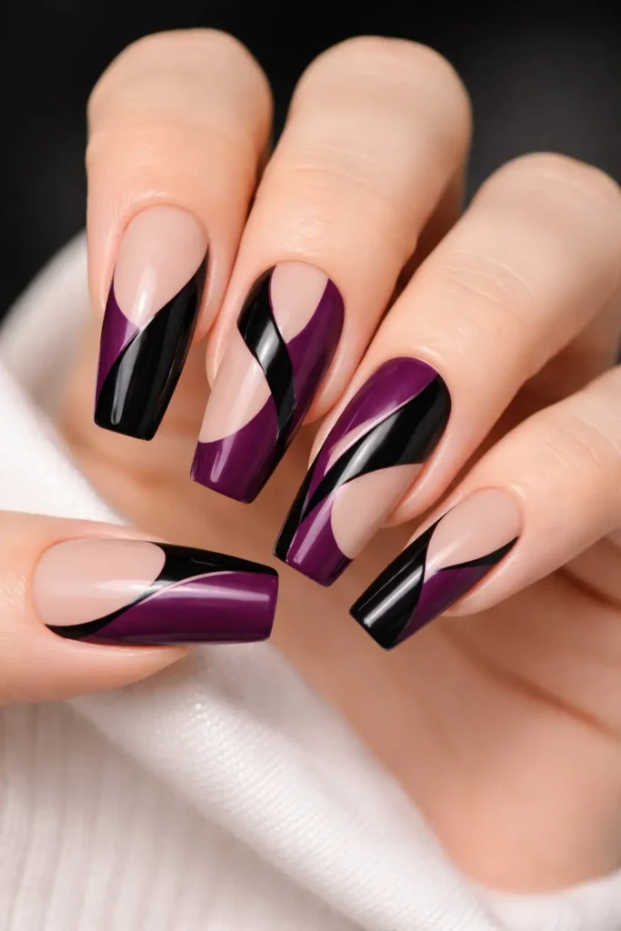 Deep plum and black negative space nail art with geometric arches on coffin nails