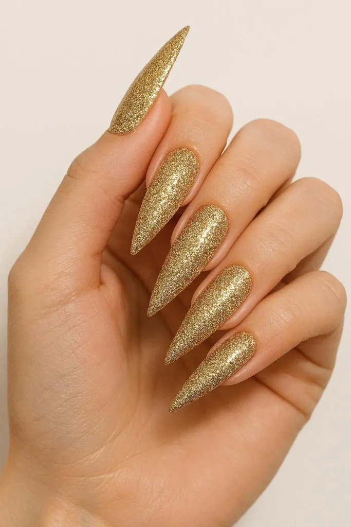 Full-coverage gold glitter nails on stiletto shape