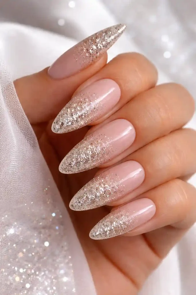 Glitter ombre almond nails fading from nude to gold shimmer