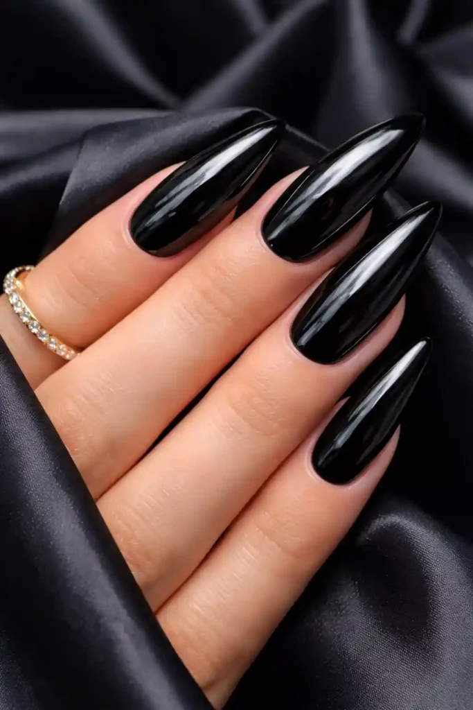 Glossy black almond nails with high-shine mirror finish
