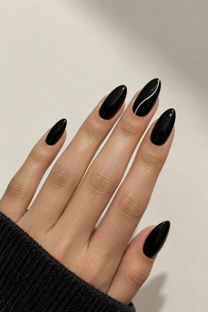 Glossy black almond nails with a thin gold line