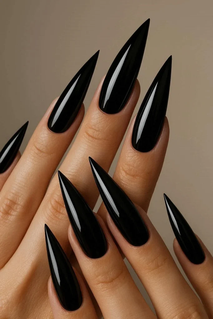 Glossy jet black stiletto acrylic nails with mirror finish