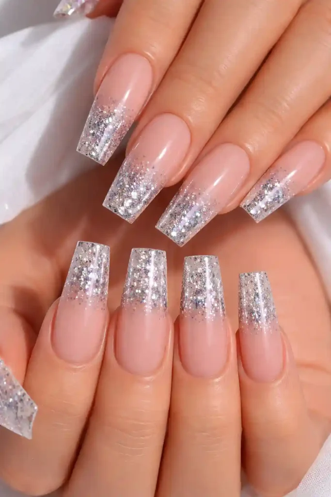 Gradient glitter coffin nails with a nude base fading into holographic glitter tips