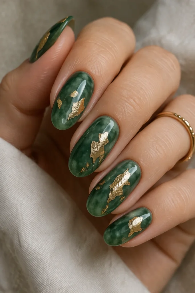 Jade green nails with abstract gold foil accents for a luxurious nail art look