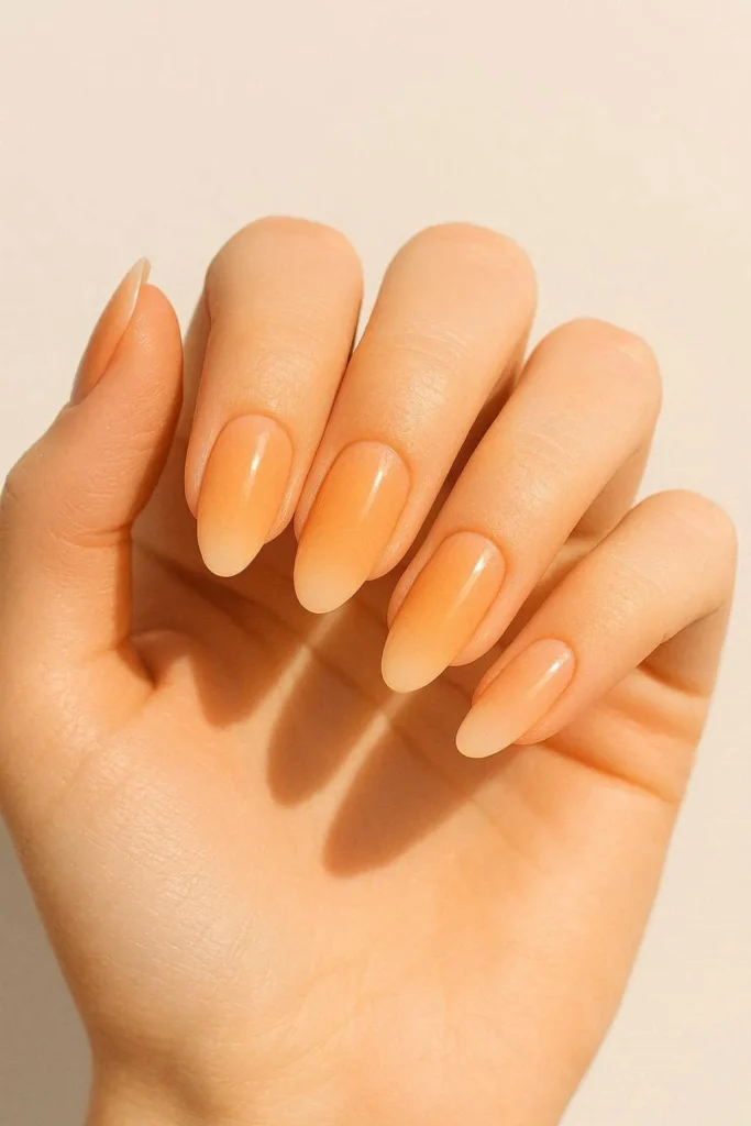  Light peach ombre nails fading into nude with a warm gradient finish
