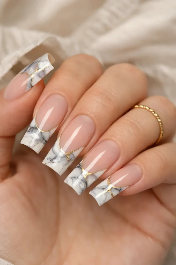 Marble french tip nails with white grey and gold vein effect on tips of coffin nails