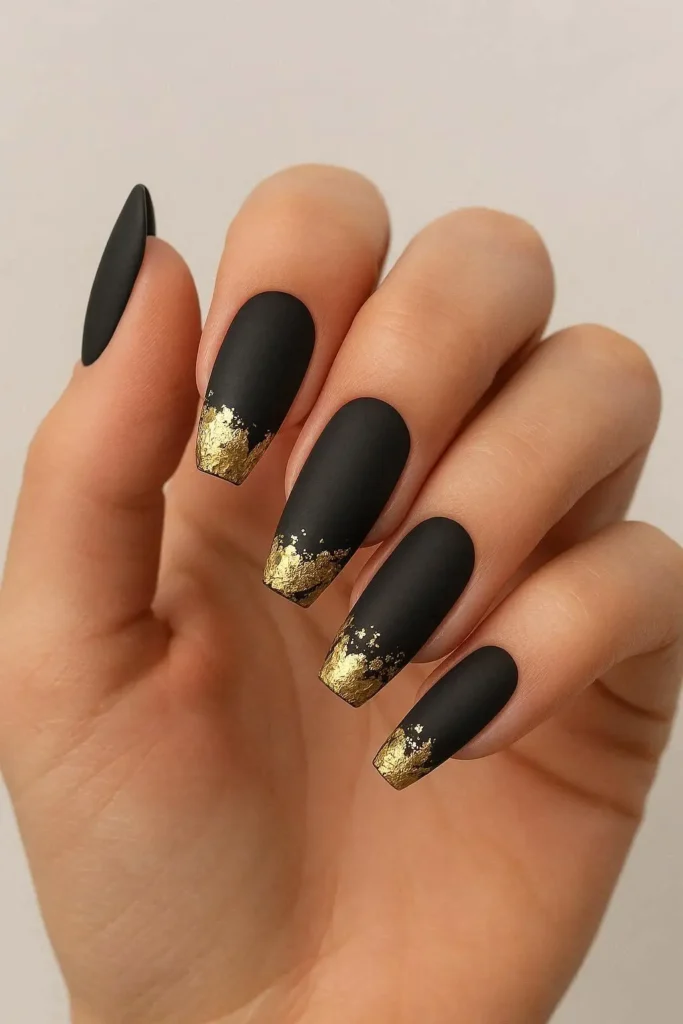Matte black nails with crinkled gold foil accents