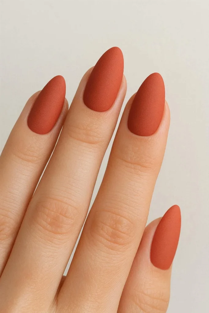 Matte coral almond shaped nails with a deep velvety finish and no shine