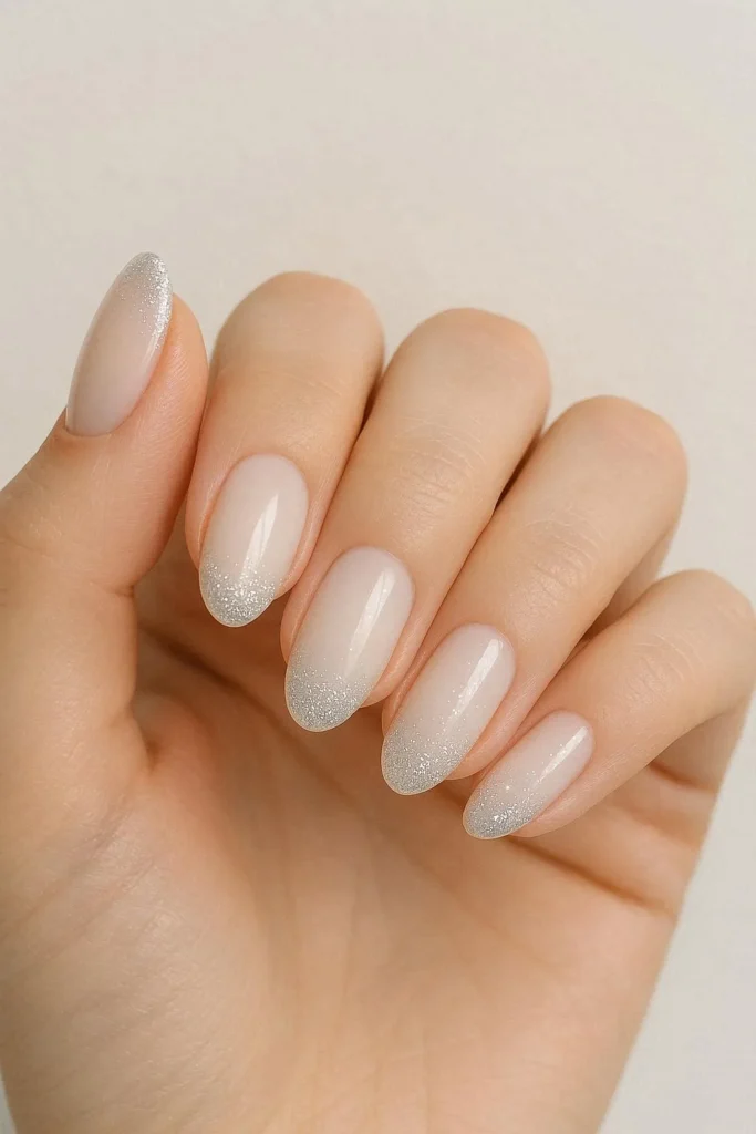 Milky nails with a soft fine glitter tip finish over a smooth creamy glossy base
