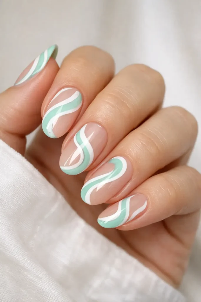 Mint swirl pastel nail designs with white abstract lines on nude base