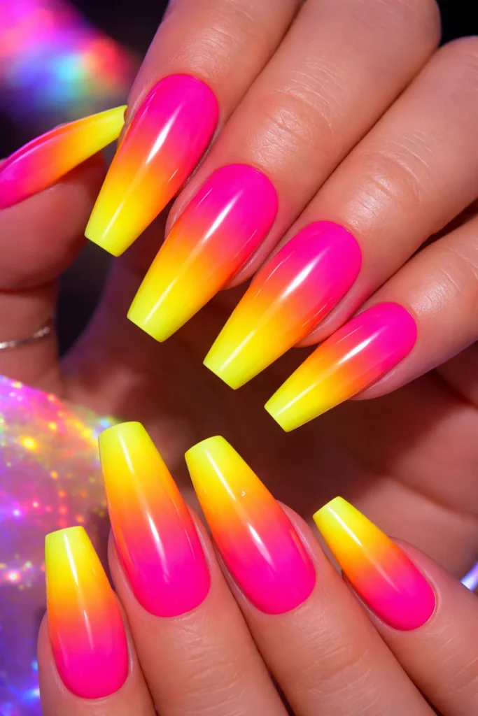 Neon pink to electric yellow glowing ombre nails for summer festivals