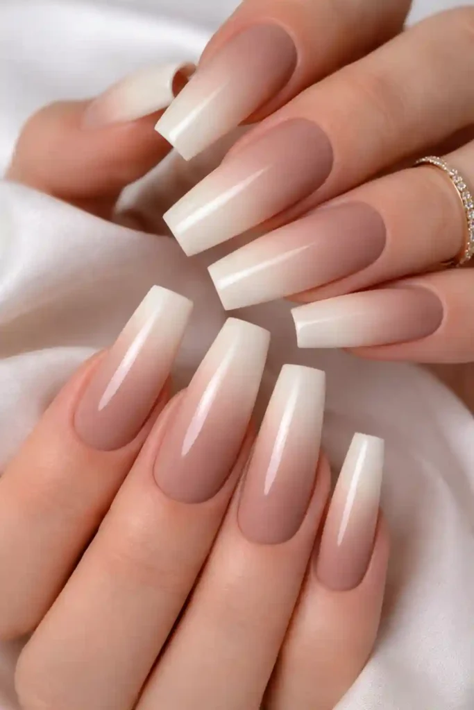 Neutral ombre coffin nails fading from warm taupe to creamy ivory with a glossy finish