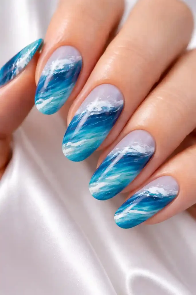 Ocean blue nails with hand-painted wave art in aquamarine and teal