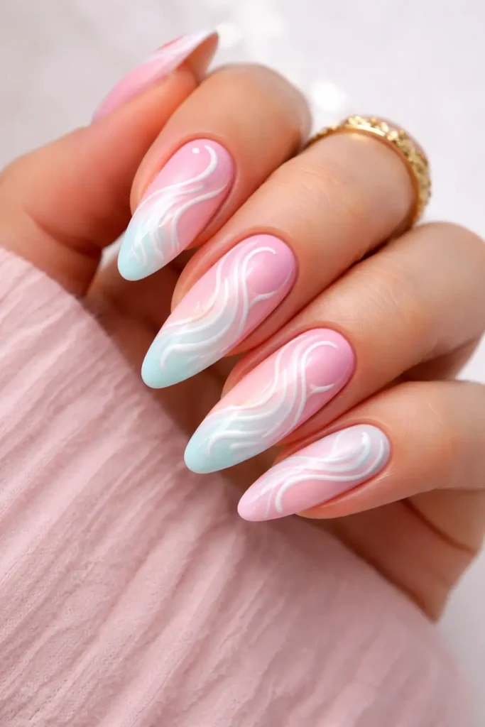 ombre swirl nails with white abstract swirls painted over a soft pastel gradient base