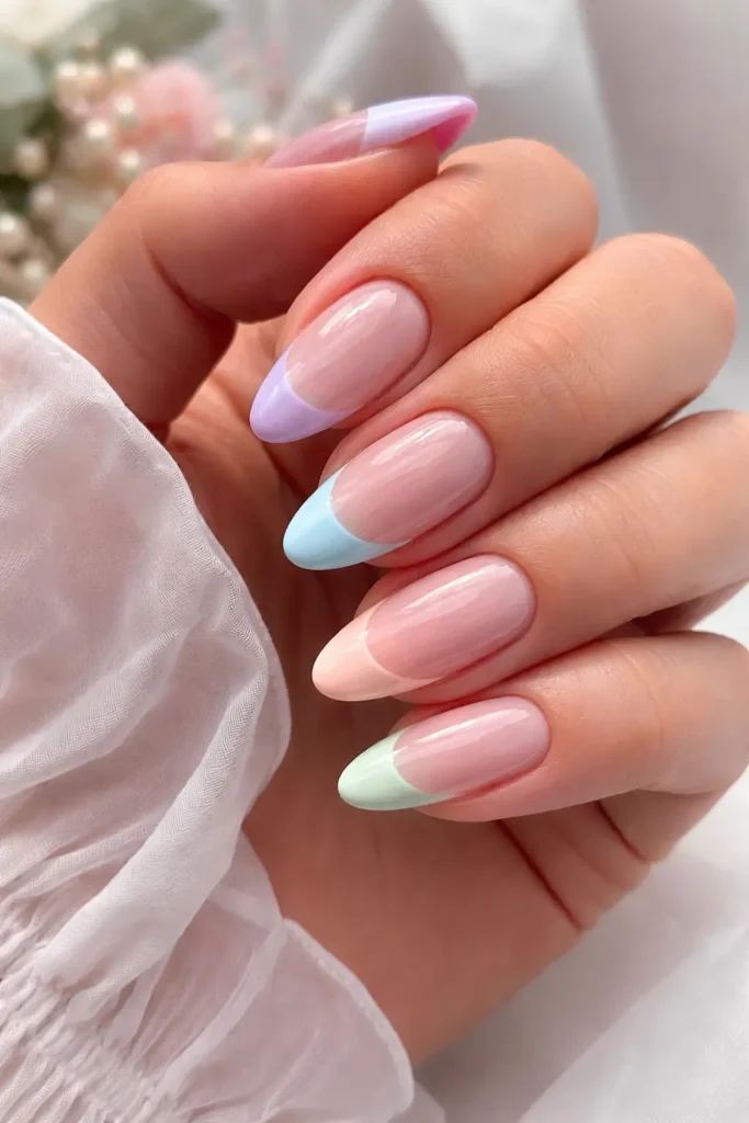 Pastel french tip nails in soft lilac baby blue and rose shades on milky base