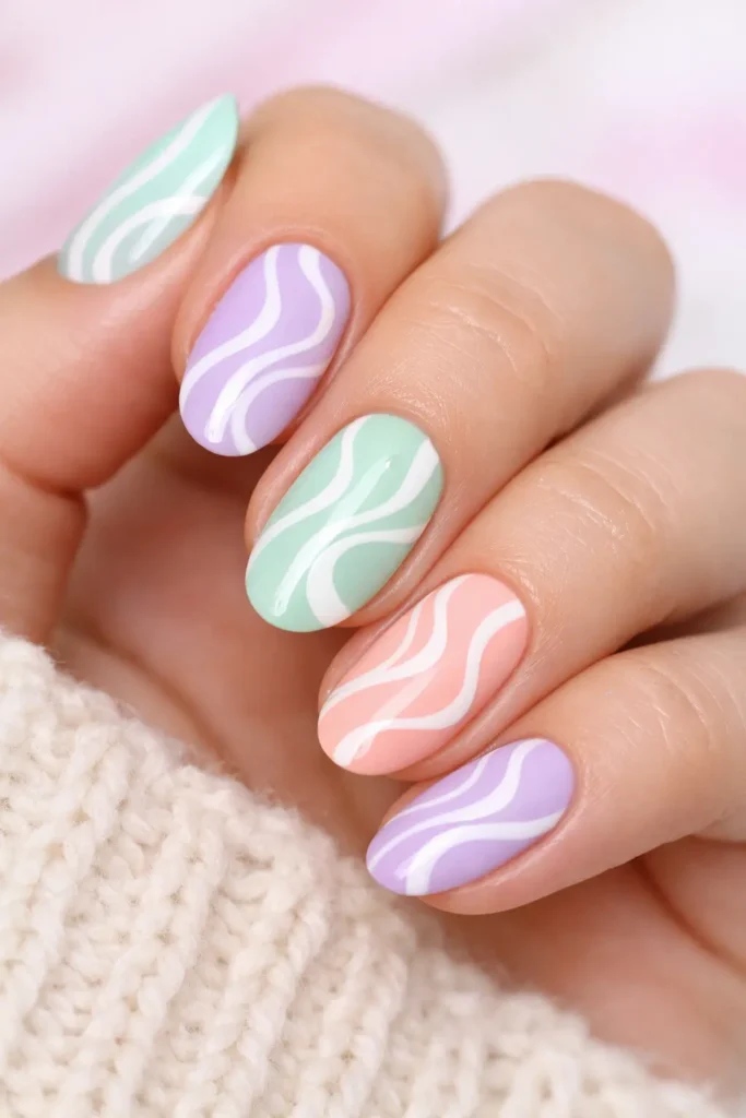 Pastel swirl spring nails with soft white cream swirls over a lilac pastel base on almond-shaped nails
