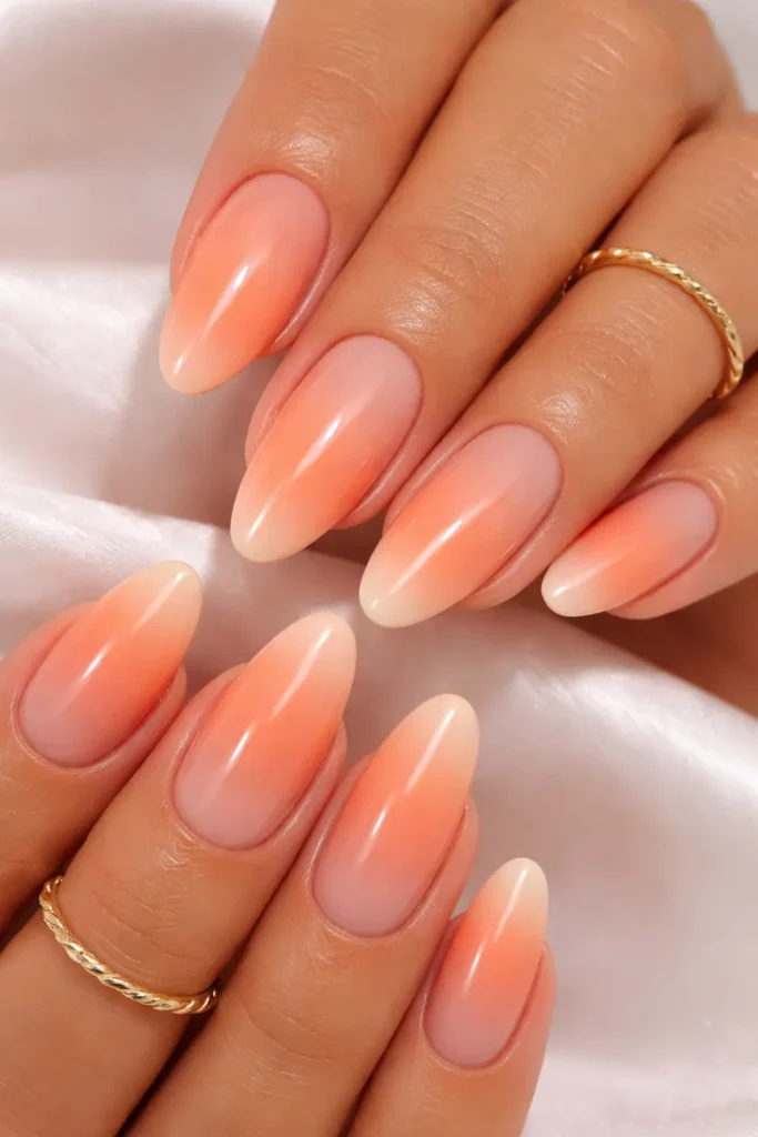 peach ombre nails blending coral apricot and champagne for a warm summer gradient manicure
